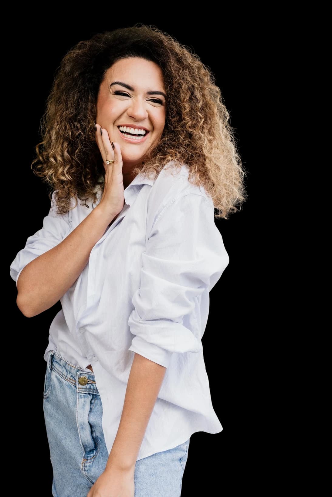 Ana Pereira sorrindo, de camisa branca e calça jeans